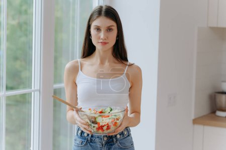 Téléchargez les photos : Régime alimentaire. Belle jeune femme manger de la salade de légumes. Concept de régime. Alimentation saine - en image libre de droit