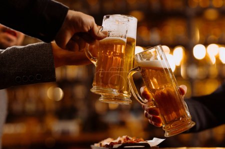Téléchargez les photos : Personnes, concept de boissons - gros plan des mains masculines cliquetis verres à bière et bretzels au bar ou pub - en image libre de droit
