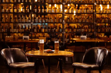 Foto de Interior del pub de la noche. cerveza en la mesa en el bar de la noche. - Imagen libre de derechos