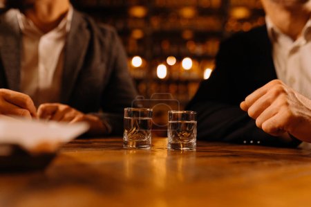Foto de Amigos brindando con tragos de vodka mientras disfrutan de una noche juntos en el pub - Imagen libre de derechos