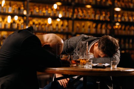 Foto de Hombres borrachos durmiendo en una mesa en un pub después del trabajo. amigos, beber alcohol - Imagen libre de derechos
