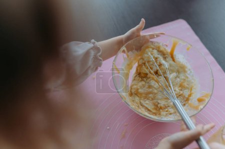 Téléchargez les photos : Petite fille pétrit de la pâte pour biscuits, gâteau, pain, crêpes. - en image libre de droit