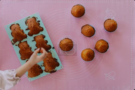 Téléchargez les photos : Biscuits éponge au chocolat fraîchement cuits sur la table. Cuisson, biscuits en forme d'ours - en image libre de droit