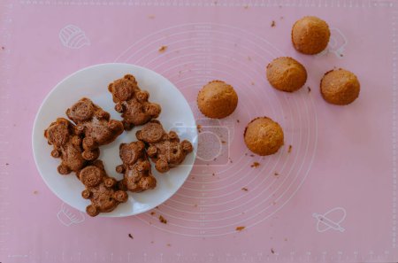 Téléchargez les photos : Biscuits éponge au chocolat fraîchement cuits sur la table. Cuisson, biscuits en forme d'ours - en image libre de droit