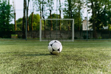 Téléchargez les photos : Le ballon de soccer se tient sur le terrain de soccer en face du but. ballon de football sur gazon artificiel - en image libre de droit
