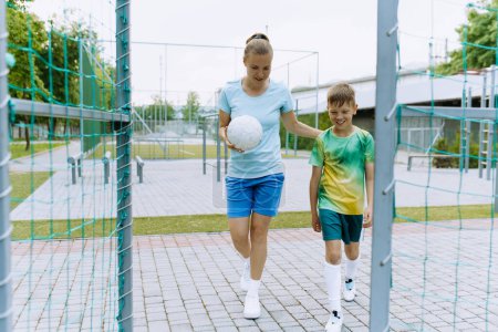 Photo for A female coach and a young football player go to training - Royalty Free Image