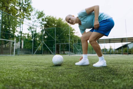 Fußballerin arbeitet mit dem Ball auf dem Fußballplatz. Fußballspieler im Training