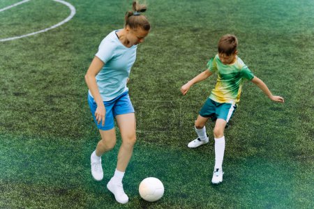 Téléchargez les photos : Une fille entraîneur et un garçon à l'entraînement de football. - en image libre de droit