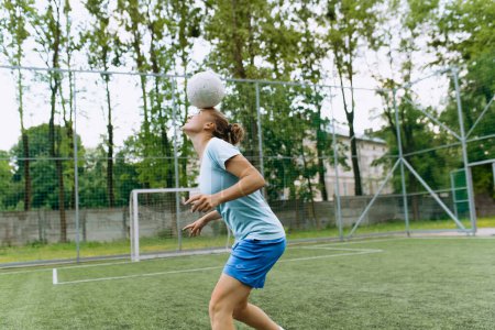 Téléchargez les photos : La joueuse de foot jongle avec le ballon sur la tête. Football - en image libre de droit
