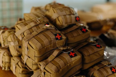 Photo for A group of military first aid kits on a table. Tactical first aid kits for the military. first aid kit camouflage - Royalty Free Image