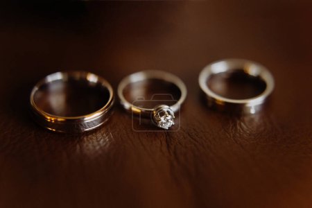 Foto de Anillos de boda de oro blanco sobre fondo de cuero. Tres anillos de boda - Imagen libre de derechos