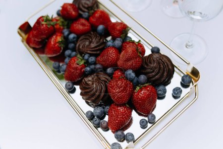 Téléchargez les photos : Dessert sucré dans un plat en verre. Buffet aux fraises, guimauves au chocolat, bleuets. - en image libre de droit