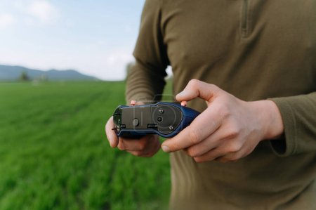 Foto de Un soldado a distancia controla un dron. Panel de control en la mano. moderno control remoto del ejército para controlar el dron - Imagen libre de derechos