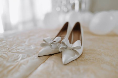 Photo for White wedding shoes with a bow on the heel on a white background. bridal shoes with a bow - Royalty Free Image