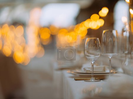 Téléchargez les photos : Réglages de table de luxe pour une cuisine raffinée avec et verrerie, beau fond flou. table de fête pour un mariage, anniversaire Préparation pour Noël vacances - en image libre de droit