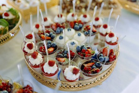 Photo for A set of sweet mini cakes with berries, raspberries, blueberries, strawberries. sweet buffet. Assorted fruit cakes for holiday - Royalty Free Image
