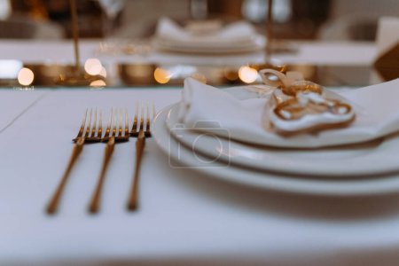 Photo for Luxury wedding reception dinner table with gold geometric decorations on table with white tablecloth. close-up of serving at a banquet - Royalty Free Image