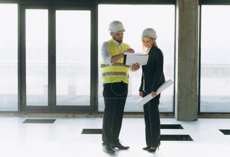 Photo for Two architect engineers talking in a constructed office building. implementation of the project. the designer and the architect lead the author's supervision - Royalty Free Image