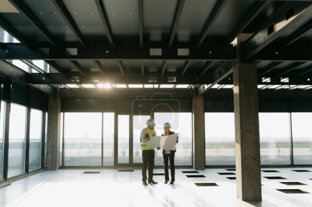 Photo for Two architect engineers are walking in a constructed office building. implementation of the project - Royalty Free Image