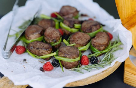 Téléchargez les photos : Morceaux de viande grillée. Rôti de bœuf, porc aux framboises et légumes verts. Concept de nourriture dans la cuisine. viande frite - en image libre de droit