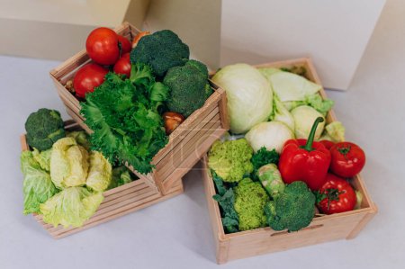 Foto de Caja de madera con verduras: col, pimienta, brócoli, cebolla, tomate, ensalada verde. feria de agricultores con la venta de verduras - Imagen libre de derechos