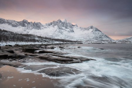 Photo for Snow covered mountain range on coastline in winter, Norway. Senja panoramic aerial view landscape nordic snow cold winter norway ocean cloudy sky snowy mountains. Troms county, Fjordgard - Royalty Free Image