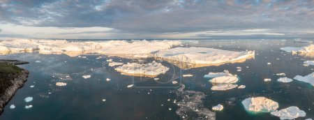 Foto de El derretimiento de un iceberg y el vertido de agua en el mar por la costa de Groenlandia Groenlandia y el increíble iceberg en el mar, todavía podemos ver esto antes de completar el cambio climático. Icefjord Calentamiento global. - Imagen libre de derechos