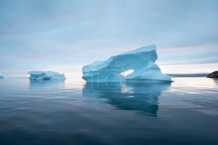 Téléchargez les photos : Paysage naturel arctique avec icebergs en Antarctique avec minuit coucher de soleil lever du soleil à l'horizon. Soleil de minuit d'été et icebergs. Grosse glace bleue dans le glacier. Changement climatique réchauffement climatique. - en image libre de droit