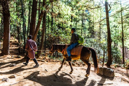 Téléchargez les photos : Un voyageur qui monte à cheval au monastère Taktsang Palphug The Tigers Nest, Paro, Bhoutan. - en image libre de droit