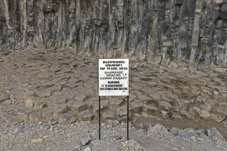 Sign saying "Warning: It is dangerous, the stones are falling" in three languages: English, Armenian, and Russian. Garni Gorge, Symphony of the Stones in Central Armenia.