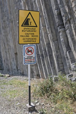 Warning sign saying "Caution falling rocks" in three languages: English, Armenian, and Russian. Garni Gorge, Symphony of the Stones in Central Armenia.