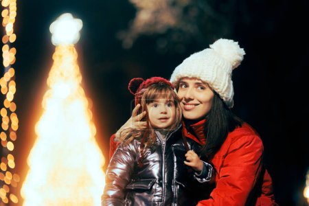 Photo for Happy Mother and Daughter Enjoying Christmas Lights Outdoors - Royalty Free Image