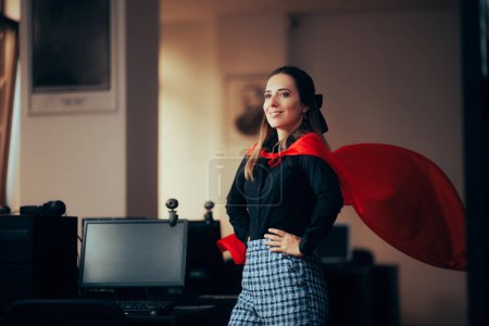 Photo for Happy Superhero Businesswoman Wearing a Red Cape in the Office - Royalty Free Image