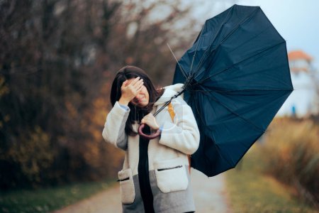Frau mit zerbrochenem Regenschirm läuft im Sturm