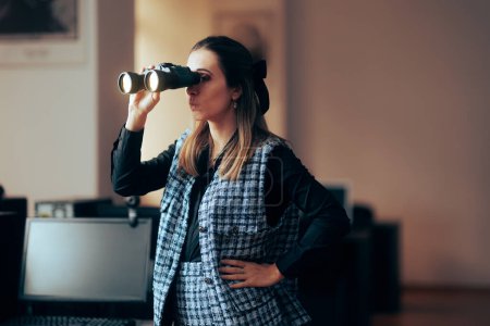 Photo for Businesswoman Looking through a Pair of Binoculars in the Office - Royalty Free Image