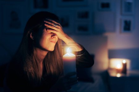 Foto de Mujer estresada sosteniendo una vela en apagón No hay situación de poder - Imagen libre de derechos