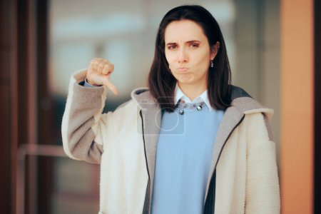 Photo for Unhappy Woman Holding Thumbs Down Outdoors - Royalty Free Image