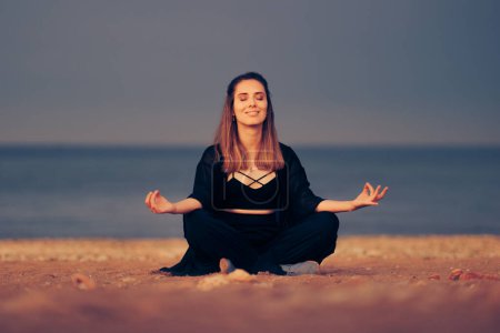 Photo for Mindful Woman Relaxing on the Beach in Yoga Lotus Pose - Royalty Free Image