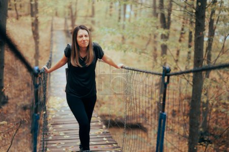 Photo for Anxious Woman Afraid of Heights Crossing a Bridge - Royalty Free Image