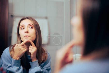 Photo for Woman Squeezing Blackheads in the Mirror Leaving Skin Marks - Royalty Free Image