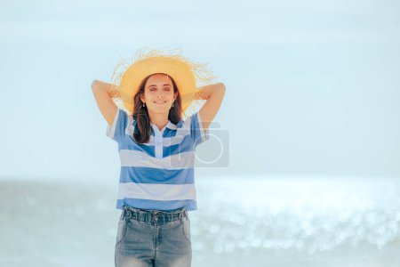 Téléchargez les photos : Fille de voyage détendue portant un chapeau de soleil à la plage - en image libre de droit