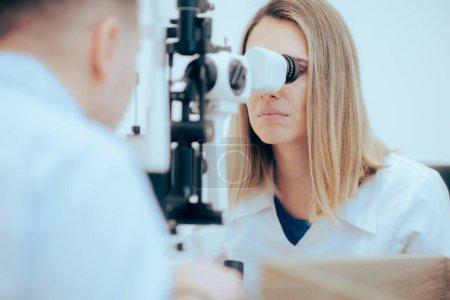 Téléchargez les photos : Médecin ophtalmologiste examinant un patient pour un diagnostic correct - en image libre de droit