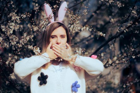 Foto de Mujer usando orejas de conejo de Pascua cubriendo su boca. - Imagen libre de derechos