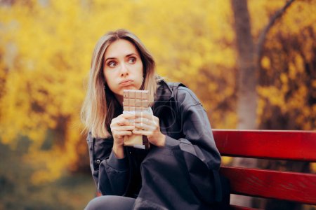 Photo for Stressed Woman Eating a Large Chocolate by Herself - Royalty Free Image