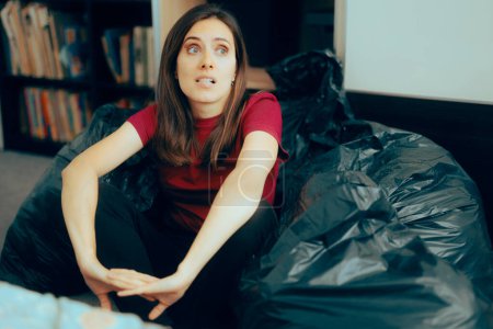 Photo for Woman Surrounded with Plastic Bags after De-cluttering and Editing her Wardrobe. - Royalty Free Image