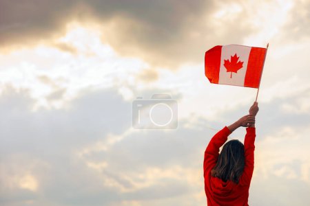 Foto de Mujer ondeando bandera canadiense mirando al cielo - Imagen libre de derechos