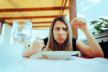 Mujer encontrando un pelo asqueroso en su sopa en un restaurante