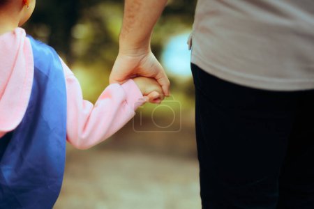 Foto de Padre e hija vistiendo superhéroe Cape Holding Hands - Imagen libre de derechos