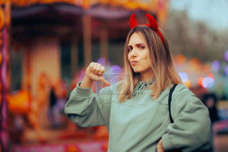 Téléchargez les photos : Femme égoïste moyenne portant des cornes diaboliques pointant vers elle-même - en image libre de droit