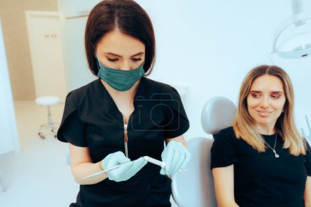 Téléchargez les photos : Dentiste travaillant sur la réparation d'une cavité à l'aide d'une substance de remplissage dentaire - en image libre de droit